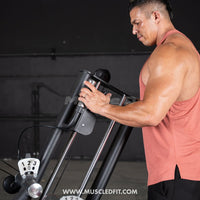 Thumbnail for Man in a tank top adjusting the settings on a black glute kick machine.