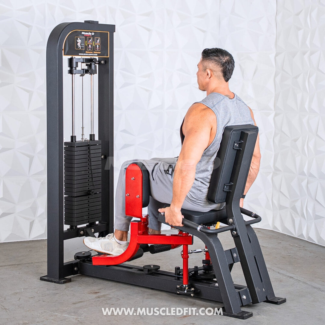 Man using a black and red selectorized inner/outer thigh combo machine with weight stack.
