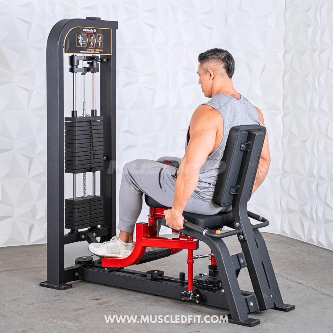 Man using a black and red selectorized inner/outer thigh combo machine with weight stack.