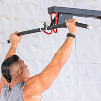 Thumbnail for Man in a gray tank top gripping a black lat pulldown bar attached to a wall-mounted gym machine.