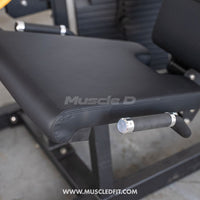 Thumbnail for Close-up of the black padded seat and armrests of a leg extension/curl machine.