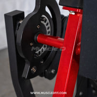 Thumbnail for Close-up of a leg extension machine's red metal arm and black selectorized weight stack mechanism.