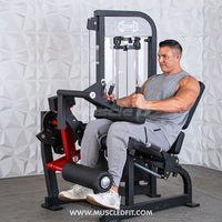 Thumbnail for Man seated on a black and red leg extension/curl machine, performing a leg extension.