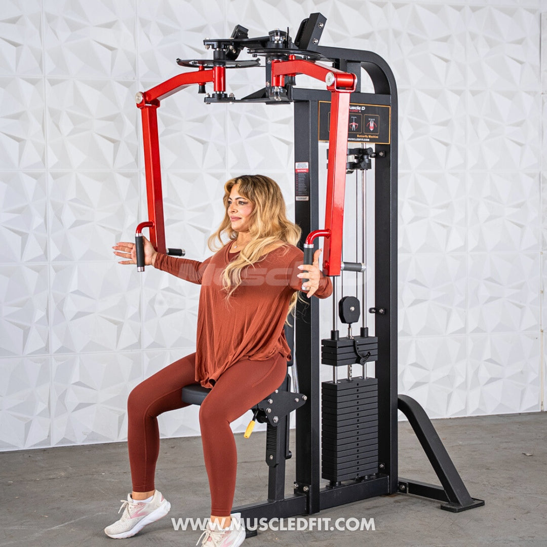 Woman using a black and red pec/rear delt combo machine with a weight stack.