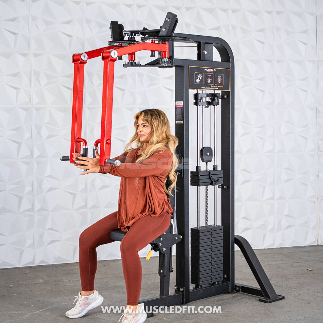 Woman using a black and red pec/rear delt combo machine with weight stack.