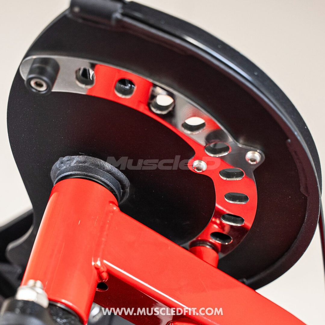 Close-up of a black and red fitness machine's adjustment mechanism with a chrome-plated, perforated arc.