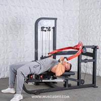 Thumbnail for Man using a multi-press chest and shoulder machine with red handles, performing a chest press.