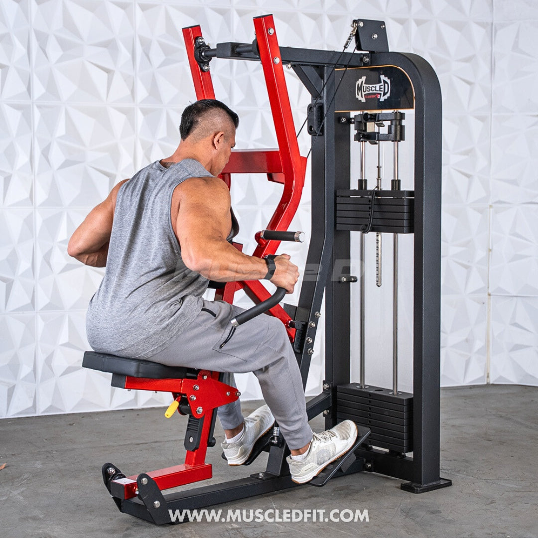 Man in gray tank top using a red and black seated row machine with weight stack.