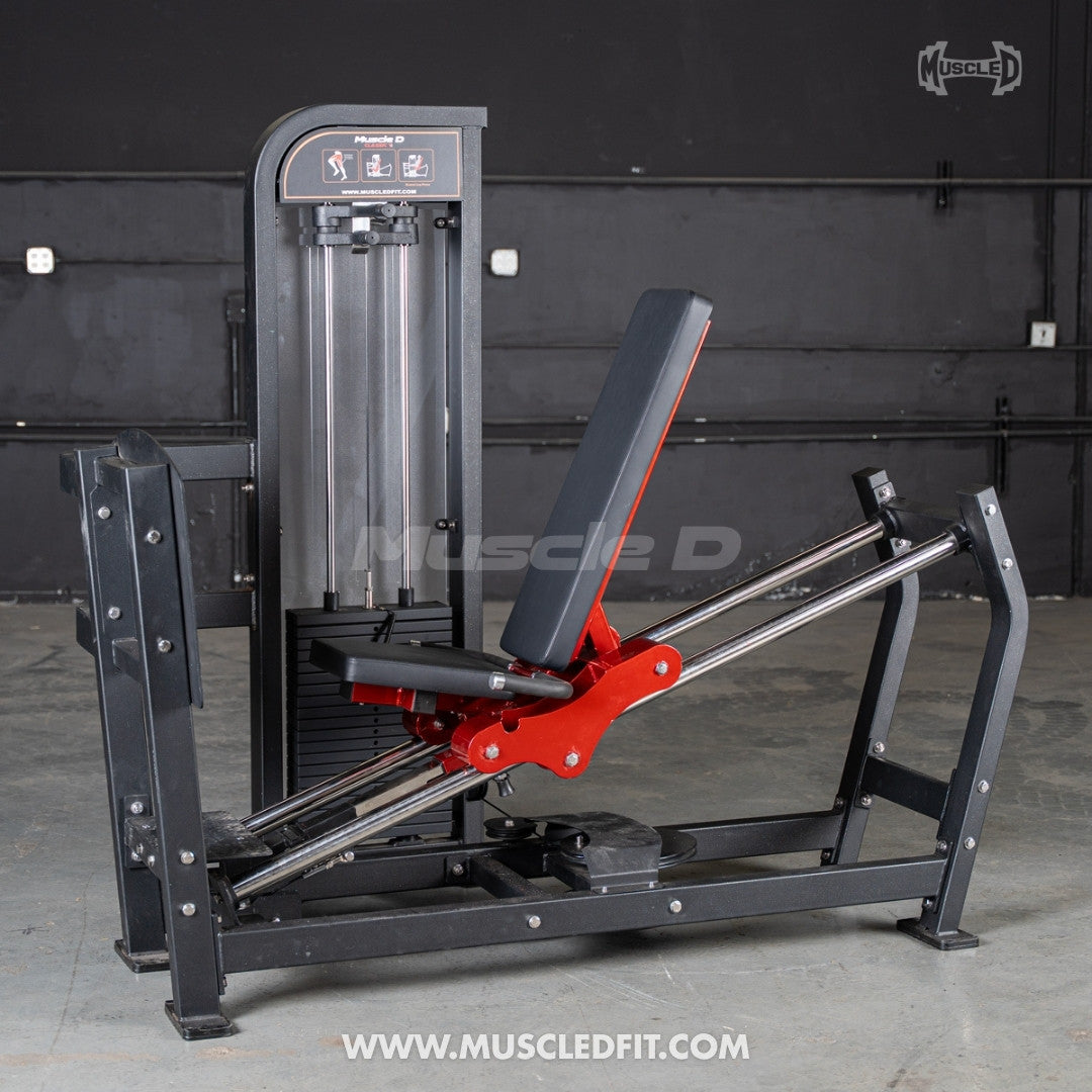 Black and red selectorized leg press machine with a weight stack in a gym setting.