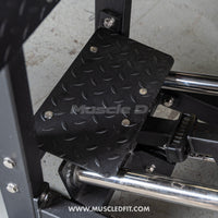 Thumbnail for Close-up of a black, diamond-plate foot platform on a leg press machine, with 