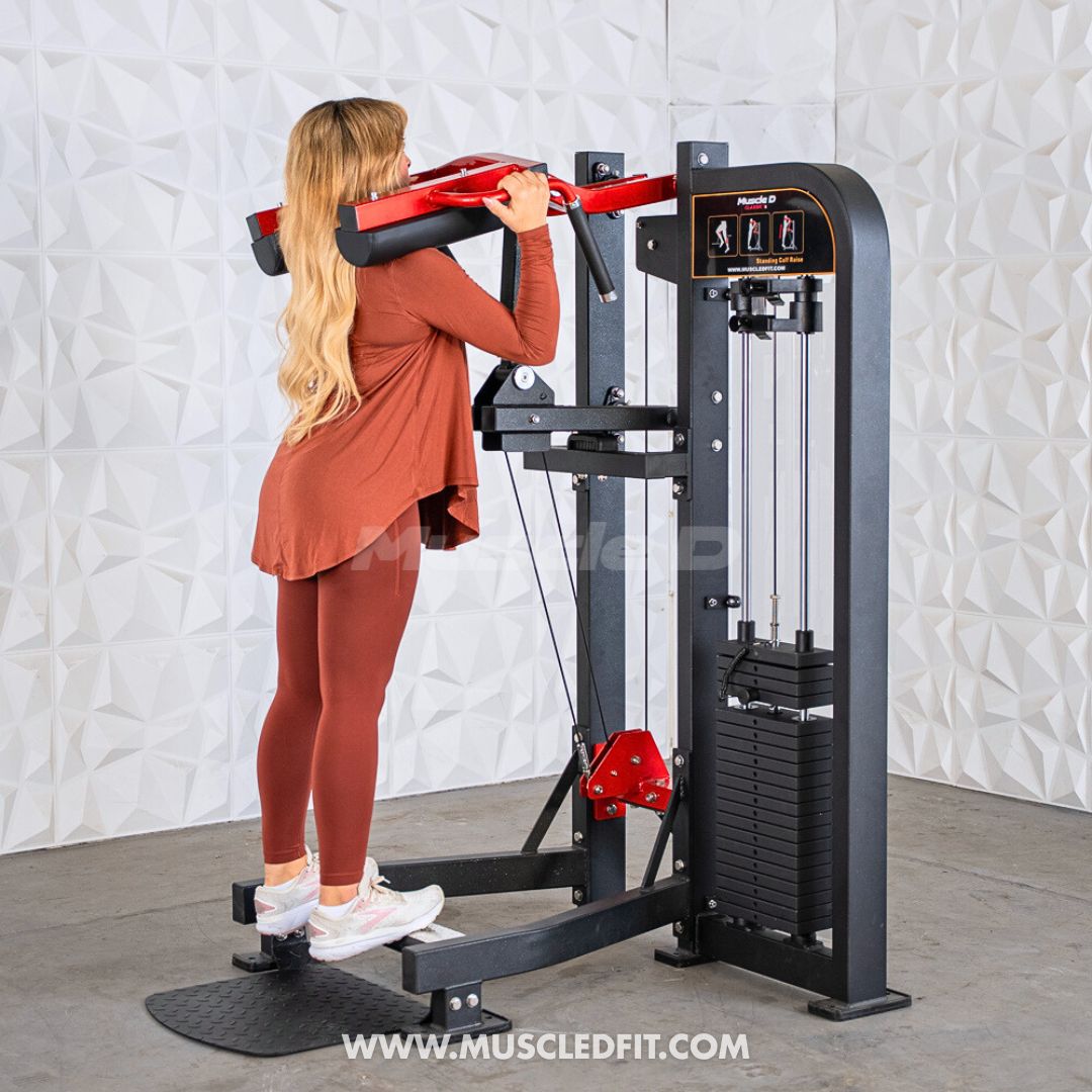Woman using a black and red selectorized standing calf raise machine with weight stack.