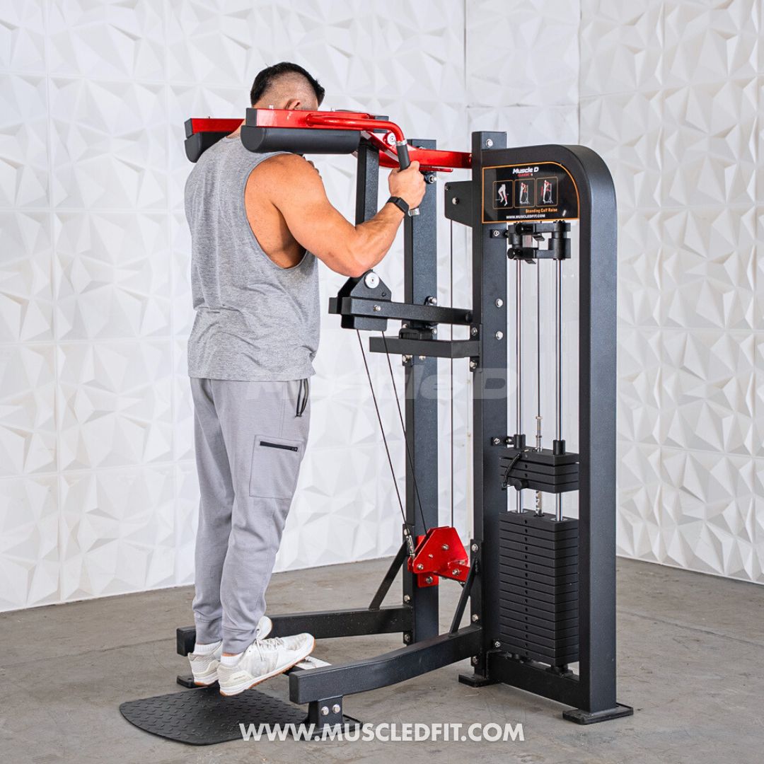 Man using a black and red selectorized standing calf raise machine with a weight stack.