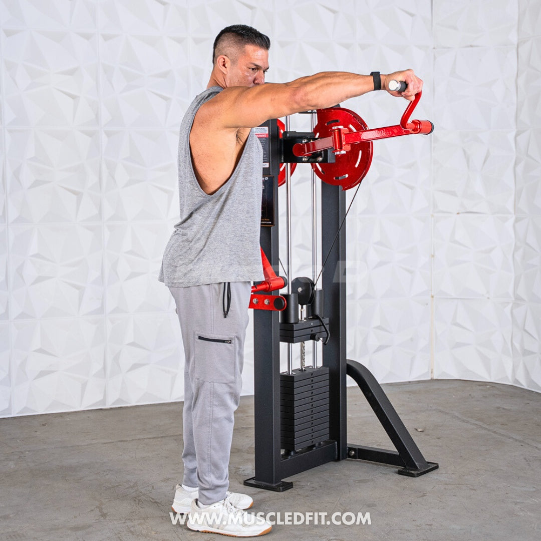 Man in grey tank top using a black and red lateral raise machine with weight stack.