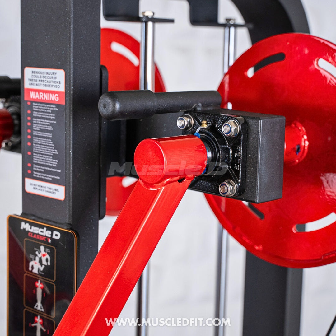Close-up of the red arm and black pivot point of a lateral raise machine.