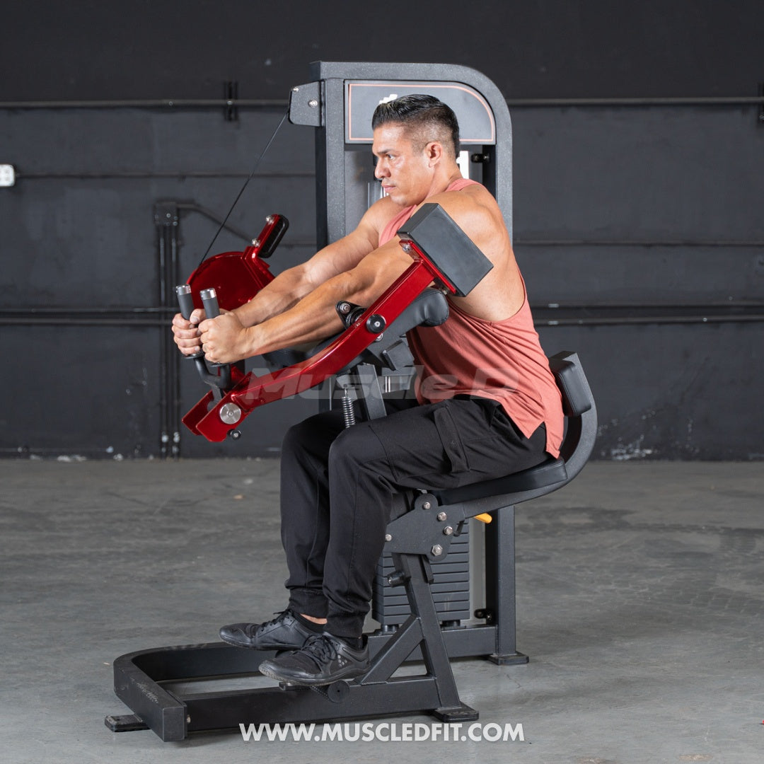 Man using a red and black selectorized triceps extension machine in a gym.