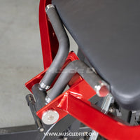 Thumbnail for Close-up of a red biceps curl machine with black padded seat and handles.