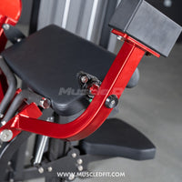 Thumbnail for Close-up of a red and black biceps curl machine, showing the padded arm rest and adjustment knob.