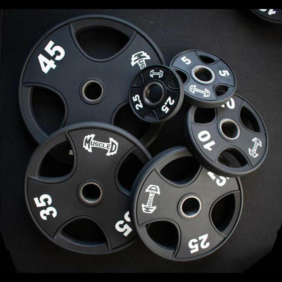 Black urethane-coated Olympic weight plates in various sizes (2.5, 5, 10, 25, 35, 45 lbs).