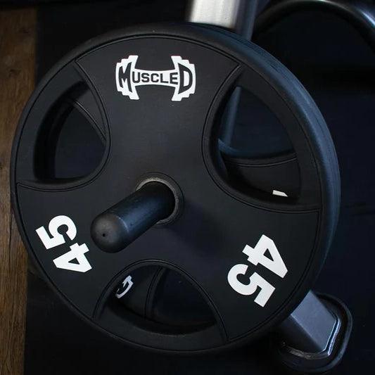 Black 45lb urethane coated Olympic weight plate with "MUSCLE D" logo, on a weight rack.