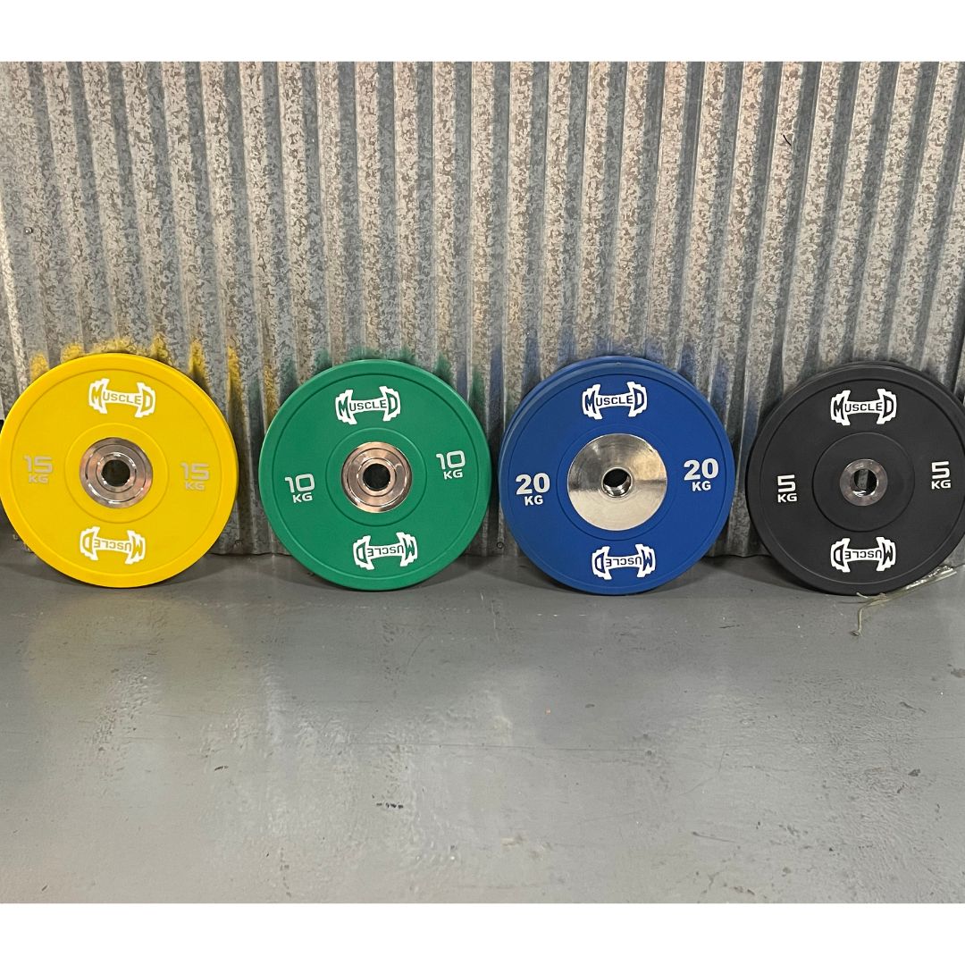 Four colorful urethane bumper plates: yellow 15kg, green 10kg, blue 20kg, and black 5kg.