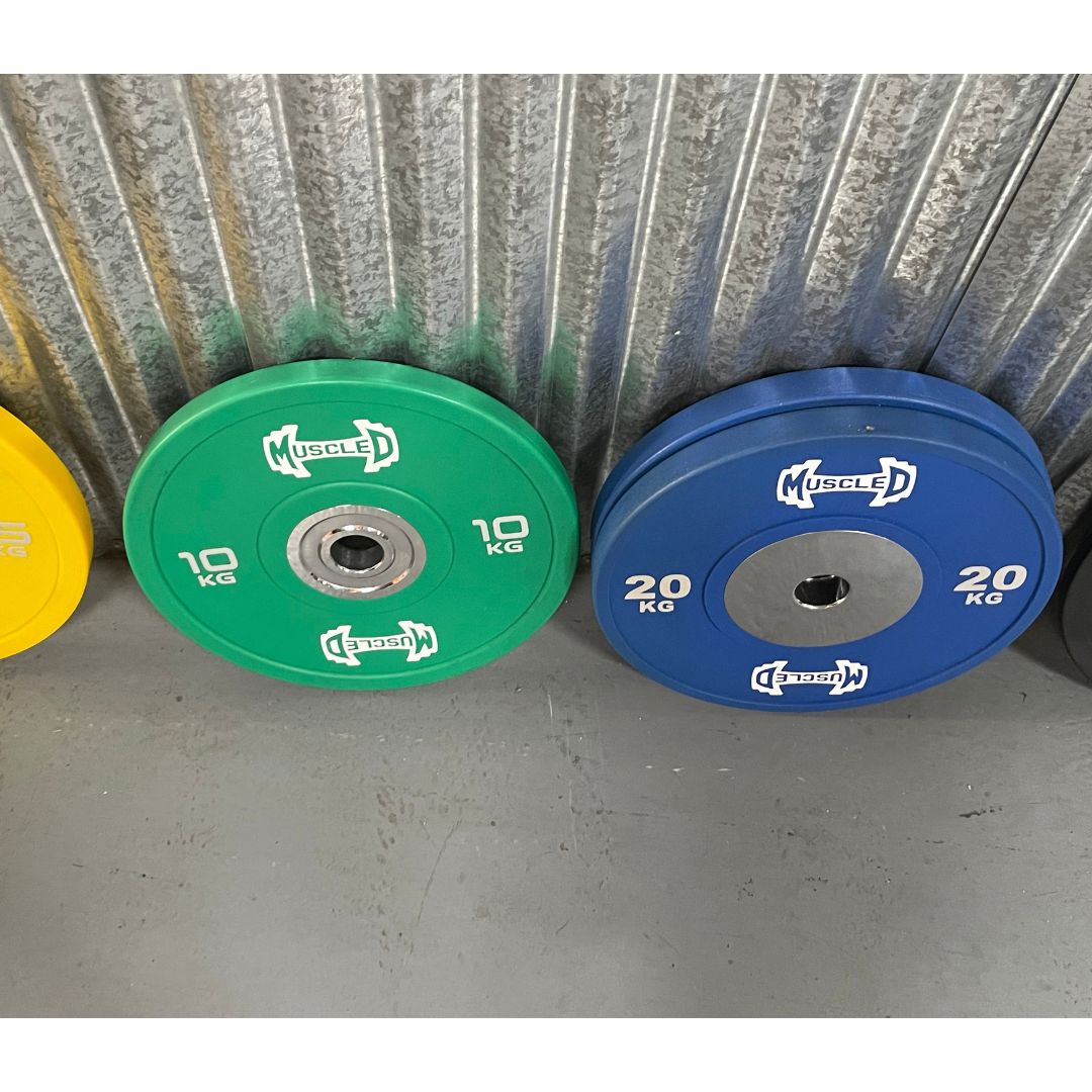 Green 10kg and blue 20kg urethane bumper plates with "MUSCLED" logo and smooth hubs.