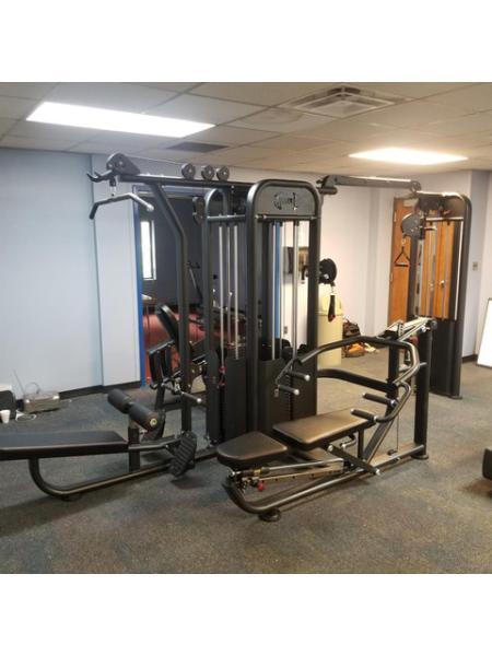Black 5-stack compact multi-gym with various stations including lat pull, low row, and leg extension.