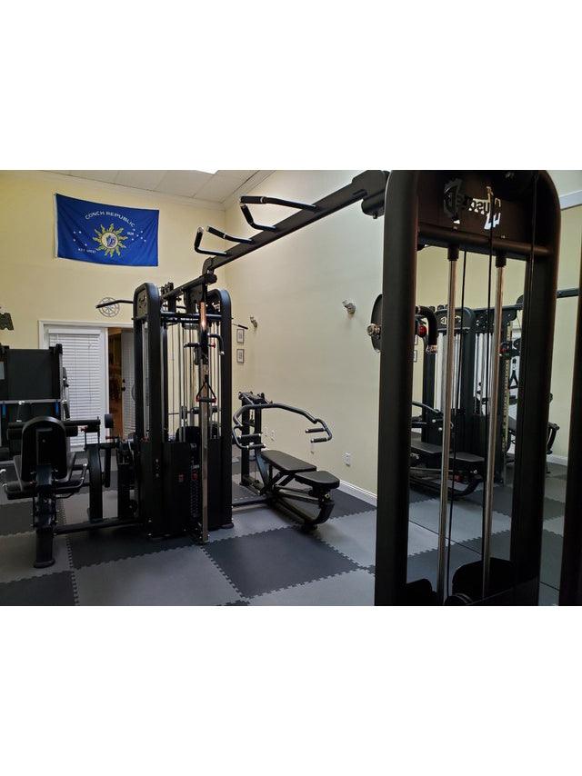 Black 5-stack multi-gym in a room with light yellow walls and a blue "Conch Republic" flag.
