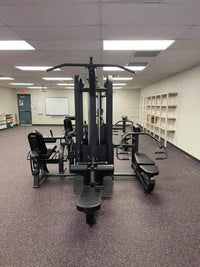 Thumbnail for Black multi-gym with multiple stations and benches on a speckled floor in a brightly lit room.