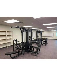 Thumbnail for Black multi-gym equipment with multiple stations in a room with purple carpet and white walls.
