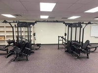 Thumbnail for Black multi-gym with various exercise stations on a purple speckled floor in a room with white walls.