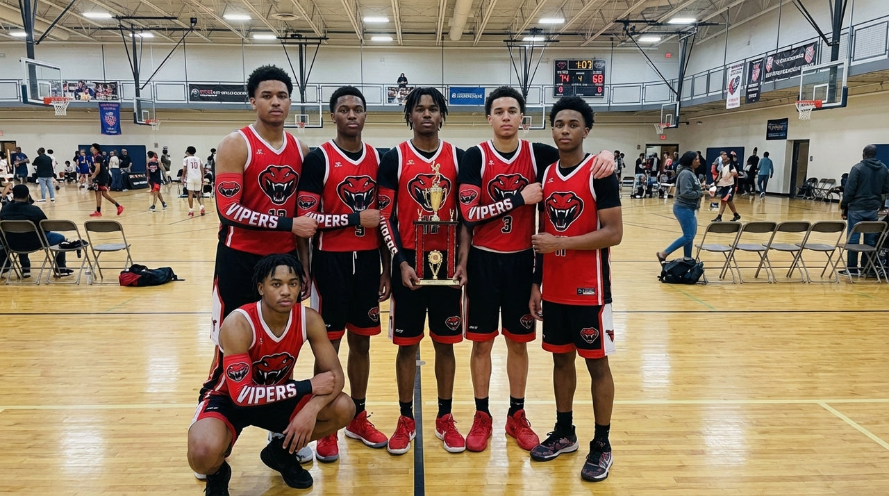Basketball team in red and black uniforms with arm sleeves, holding a trophy on a court.