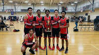 Thumbnail for Basketball team in red and black uniforms with arm sleeves, holding a trophy on a court.