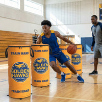 Thumbnail for Basketball player dribbling around three orange custom pop-up defenders with "Golden Hawks Basketball" logo.