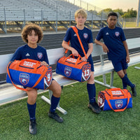 Thumbnail for Three boys in soccer uniforms with personalized orange and blue duffle bags on a field.