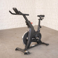 Thumbnail for Black upright exercise bike with adjustable seat and handlebars on a concrete floor.