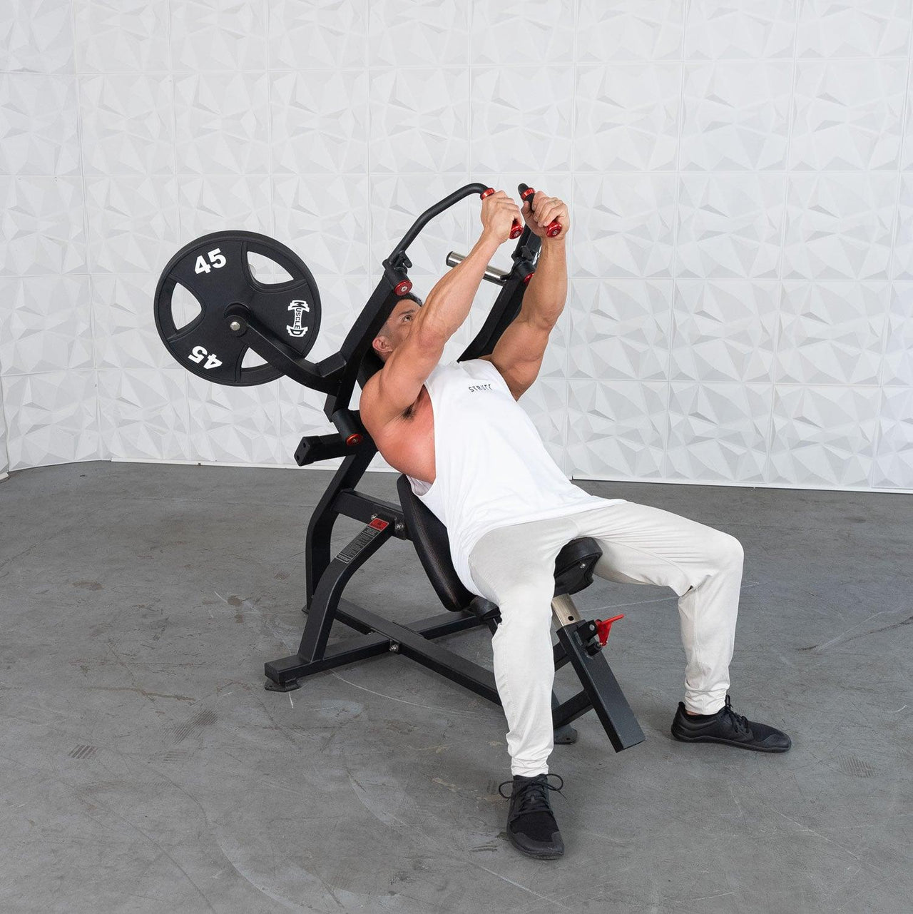 Man using an incline pec fly machine with a 45lb weight plate.