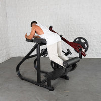 Thumbnail for Man using a black and red plate-loaded reverse hyper machine with a 45lb weight plate.