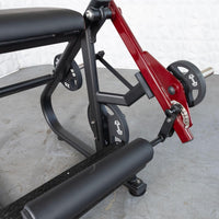 Thumbnail for Close-up of a black and red plate-loaded reverse hyper machine with an adjustable roller pad.