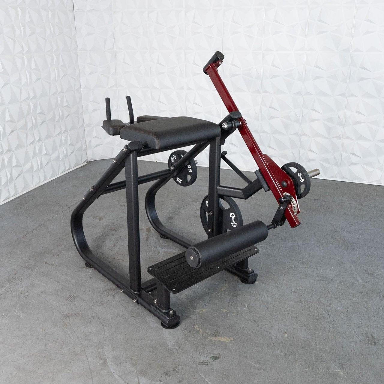 Black and red plate-loaded reverse hyper machine with an adjustable roller pad and weight plates.