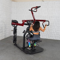 Thumbnail for Woman using a red and black plate-loaded rotary lat pull-down machine.