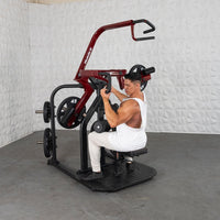 Thumbnail for Man in white tank top using a red and black rotary lat pull-down machine with 45lb plates.