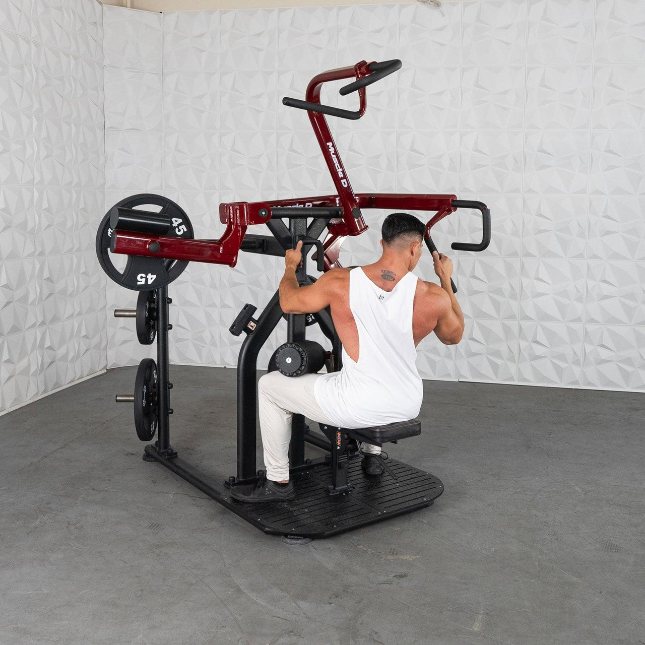 Man using a red and black plate-loaded lat pull-down machine with 45lb weights.