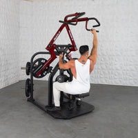 Thumbnail for Man in white tank top using a red and black plate-loaded lat pulldown machine.