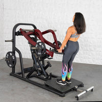 Thumbnail for Woman using a red and black plate-loaded chest-supported row machine with 25lb and 45lb weights.