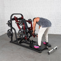 Thumbnail for Man adjusting a chest-supported plate-loaded row machine with weight plates in a gym.