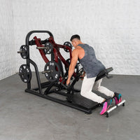 Thumbnail for Man using a chest-supported plate-loaded rowing machine with black and red frame and weight plates.