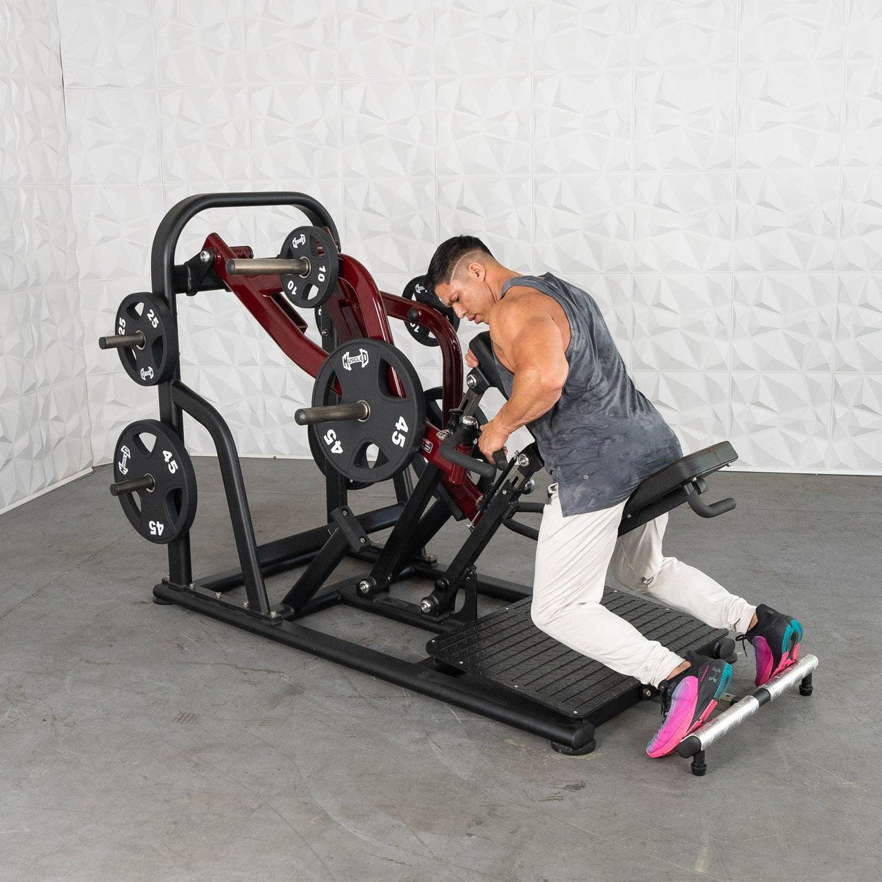 Man using a chest-supported plate-loaded row machine with 45lb plates.