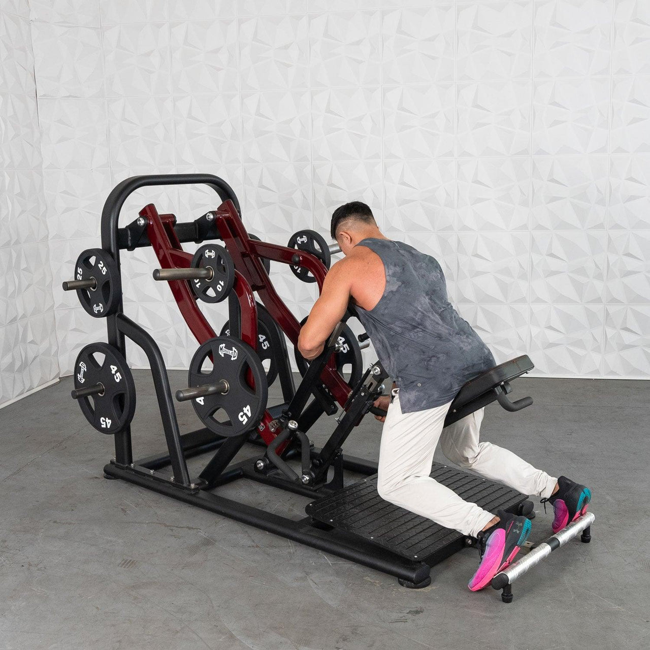 Man using a chest-supported plate-loaded row machine with 45lb plates.
