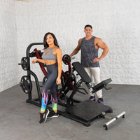 Thumbnail for Man and woman standing next to a black and red plate-loaded chest-supported row machine.