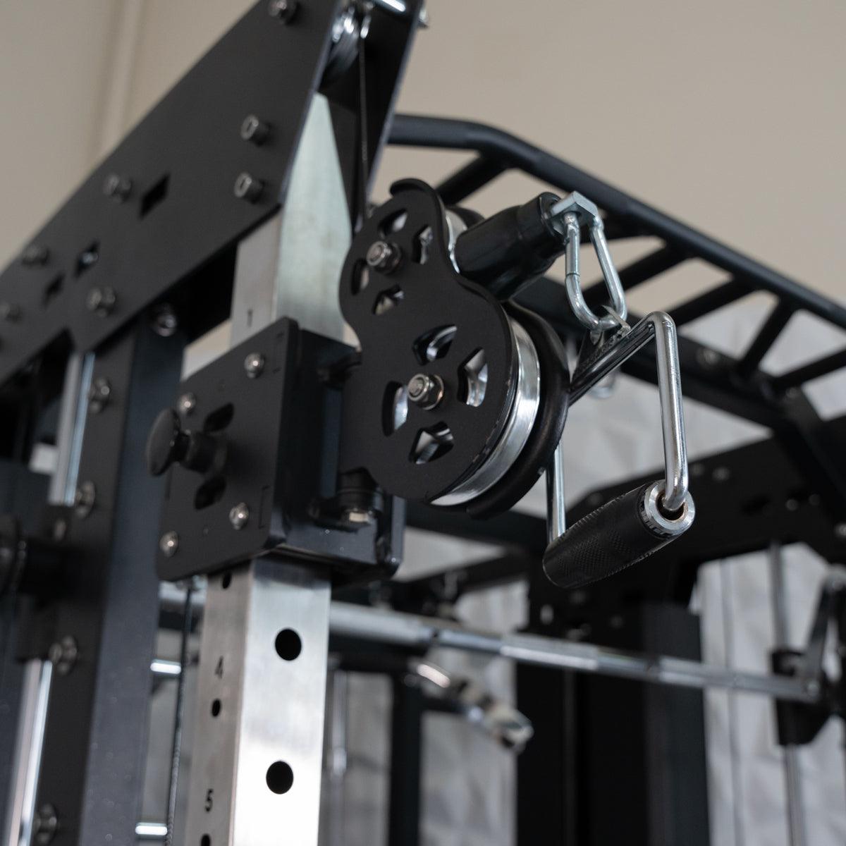 Close-up of a black and silver pulley system with a handle attached to a fitness machine.